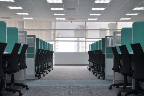 An Aisle Between Two Rows of Ocean-Blue Office Cubicles