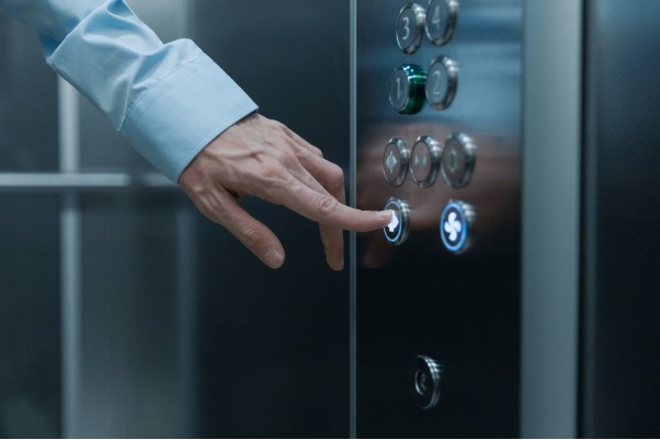 A Faceless Person Pressing an Elevator Button